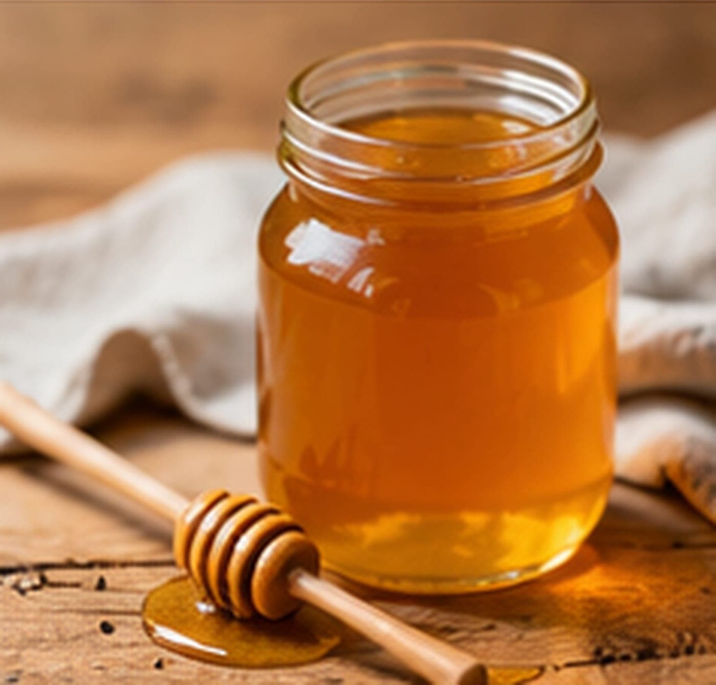 A jar of raw honey with a wooden dipper